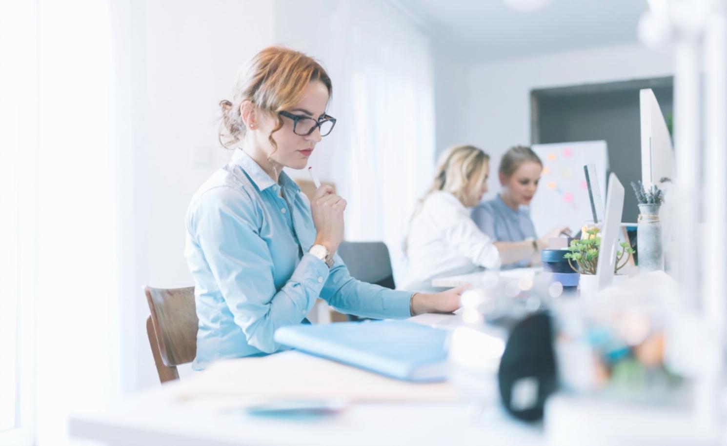 Personne analysant des documents financiers sur un bureau moderne